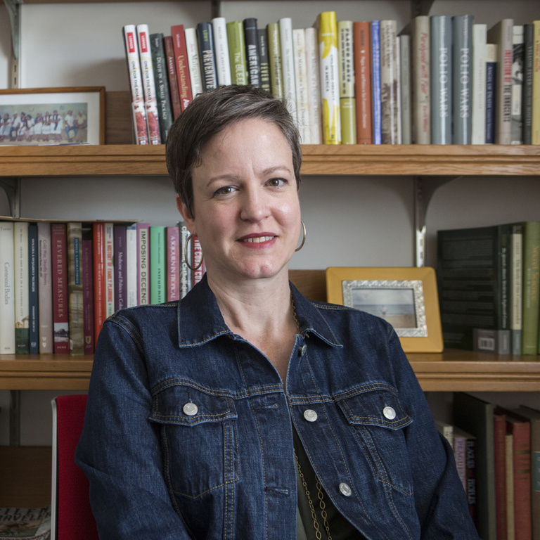 photo of Mariola Espinosa in front of book shelves